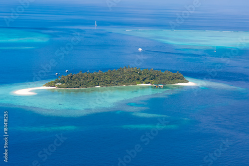 Maldives island aerial landscape view. Beautiful blue sea and luxury water villas. Seaplane aerial view of Maldives atoll and coral reef