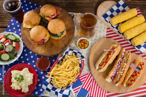 Hot dogs and burgers on wooden table with 4th July theme