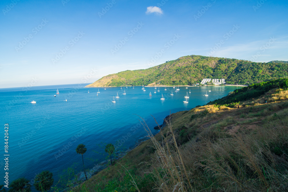 Blue sea rock beach with island and yacht boat