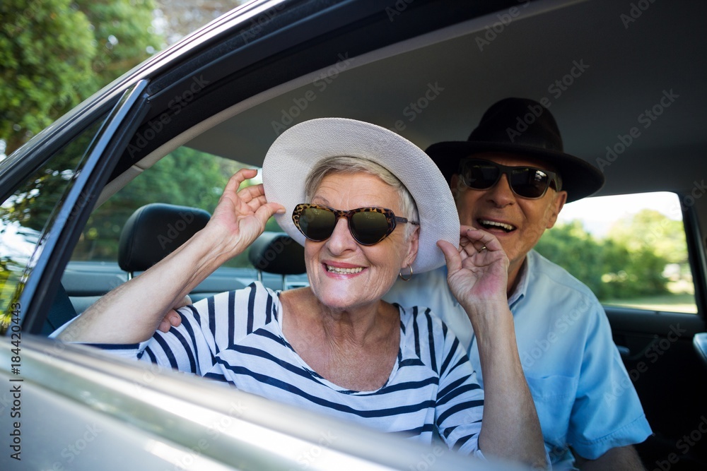 Senior couple looking through car window Senior couple looking through car window