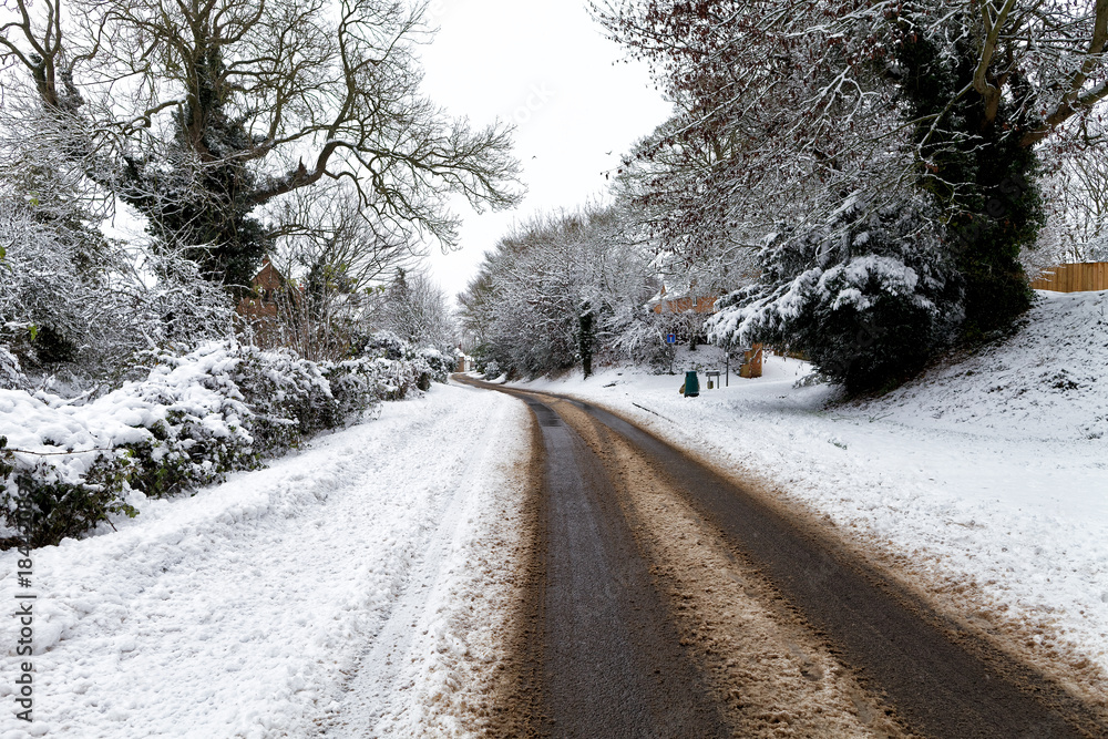 Obraz premium Snow covered road through a small village