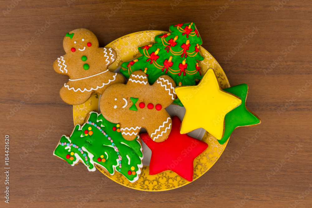 Plate with tasty Christmas cookies on wooden table