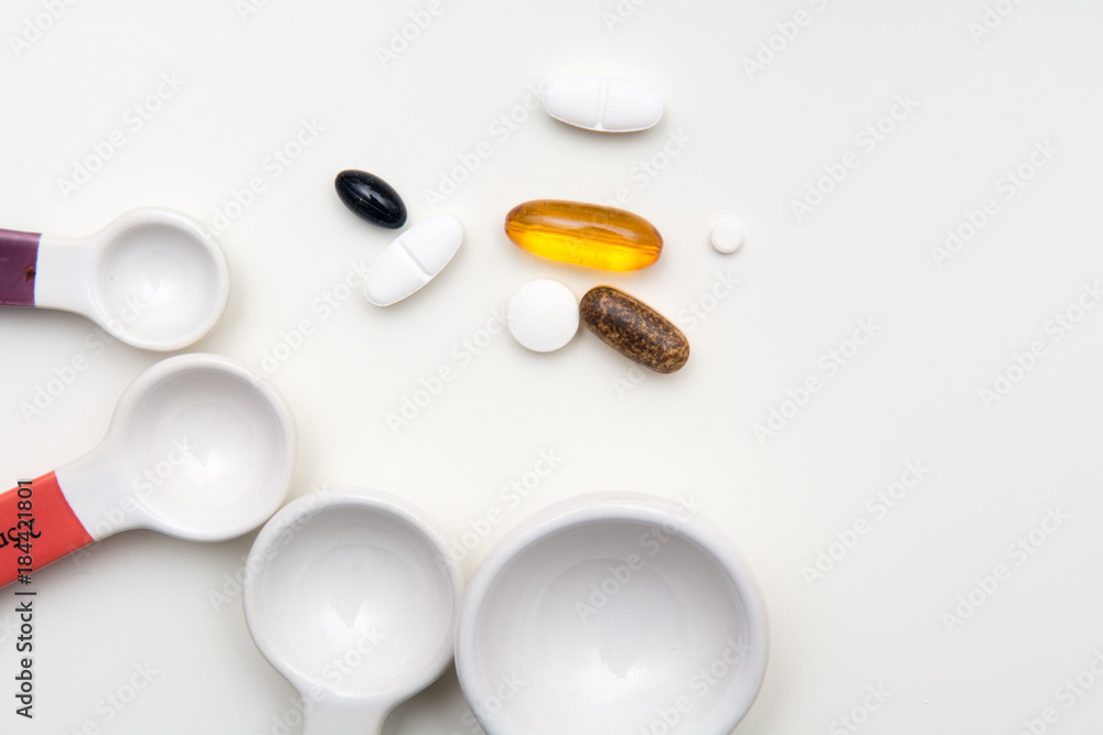 Medicine pills and tablets with spoons to measure medicine dose. Medical background Medicine pills and tablets with spoons to measure medicine dose. Medical background