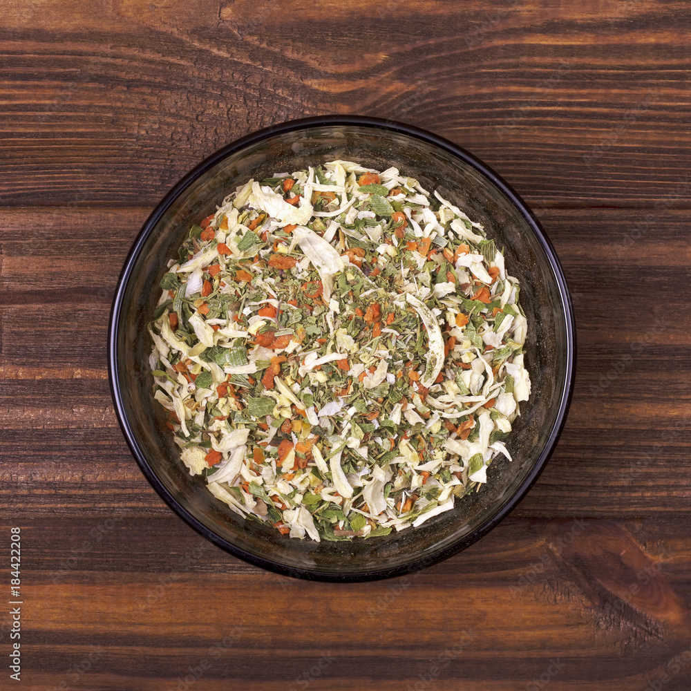 Spice mix - celery, parsley, parsnip, leeks, onions, dill, basil, carrot in a bowl on a wooden background Spice mix - celery, parsley, parsnip, leeks, onions, dill, basil, carrot in a bowl on a wooden background