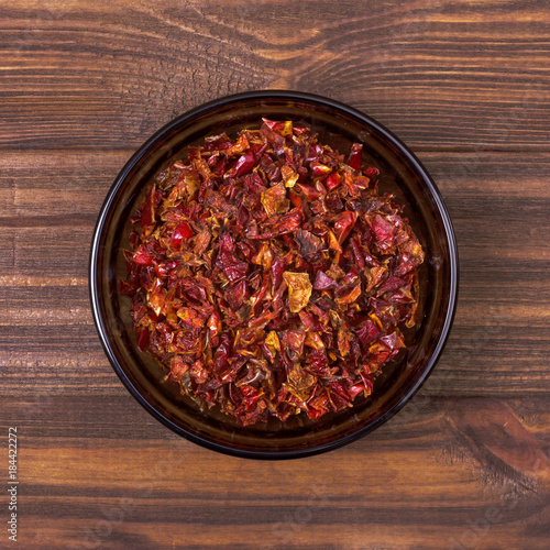 Red paprika spice in a bowl on a wooden background