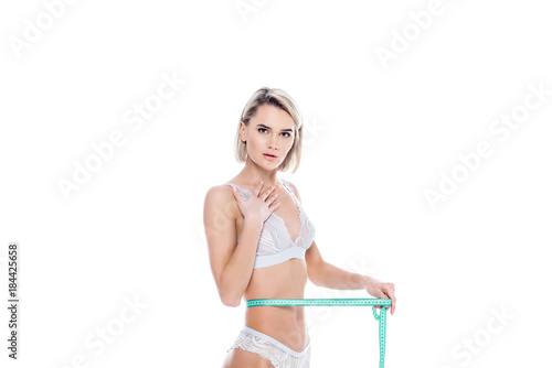 shocked girl in lingerie measuring her slim waist, isolated on white