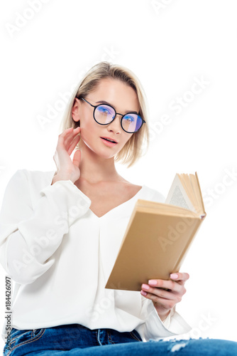 beautiful blonde girl in eyeglasses reading book, isolated on white