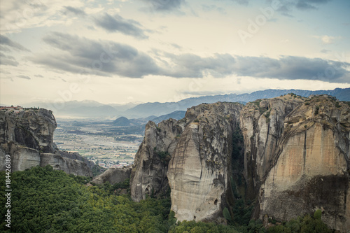 Landscape of monasteries of Meteora in Greece in Thessaly at the early morning. Cliffs of Meteora opposite a morning cloudy sky background