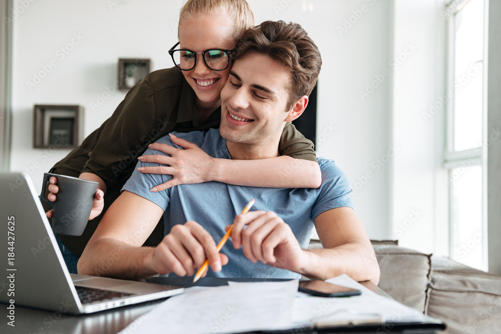 Smiling couple using laptop computer at home Smiling couple using laptop computer at home