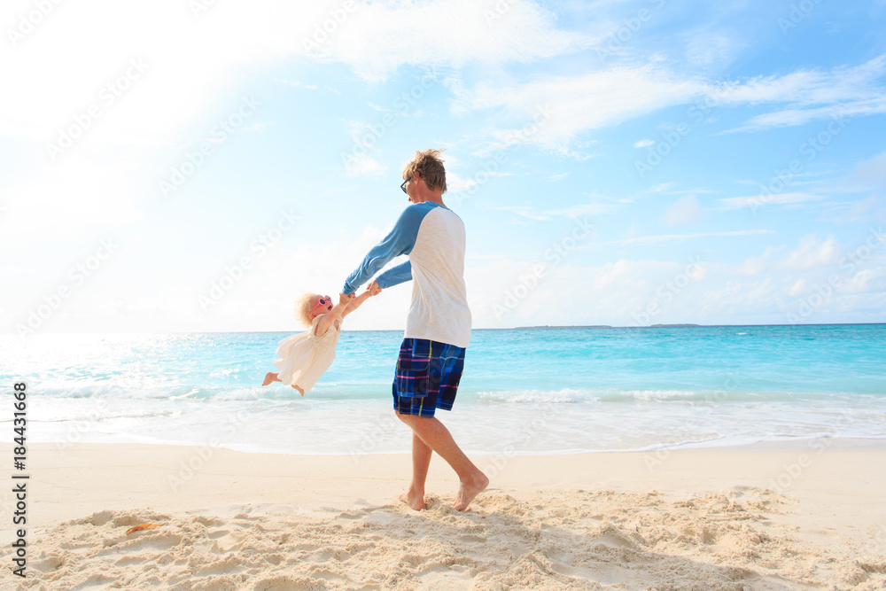 father and daugher play on tropical beach