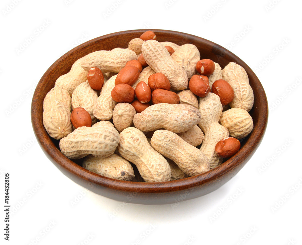Dried peanuts in closeup in wooden bowl on white background Dried peanuts in closeup in wooden bowl on white background