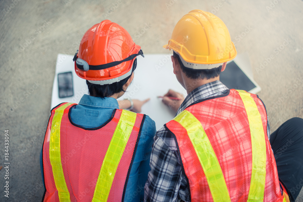 Engineer or Architect working at Construction Site with white paper, Focus on the paper Engineer or Architect working at Construction Site with white paper, Focus on the paper