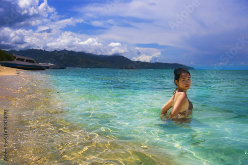 Asian Chinese woman having bath on Thailand island beach with amazing beautiful turquoise color water under summer blue sky