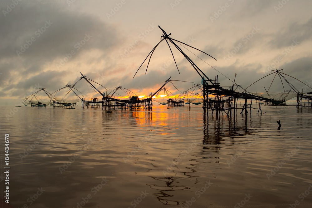 Beautiful landscape view sunrise at Pak Pra lake, Pattalung, Thailand with twilight sky background,silhouette of traditional fishing method using a bamboo square dip net. Beautiful landscape view sunrise at Pak Pra lake, Pattalung, Thailand with twilight sky background,silhouette of traditional fishing method using a bamboo square dip net.