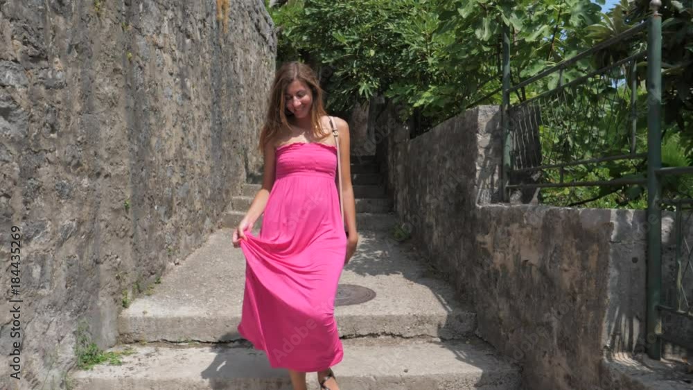 Brunette Smiling Woman In Pink Dress Goes On Stone Street, Slow motion, 4K Brunette Smiling Woman In Pink Dress Goes On Stone Street, Slow motion, 4K