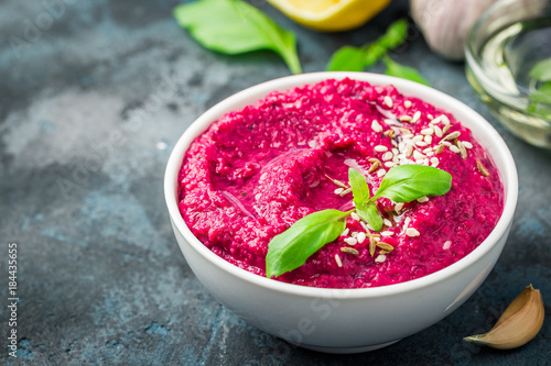 Gluten free vegan roasted beetroot hummus on dark blue background. Selective focus, copy space. 