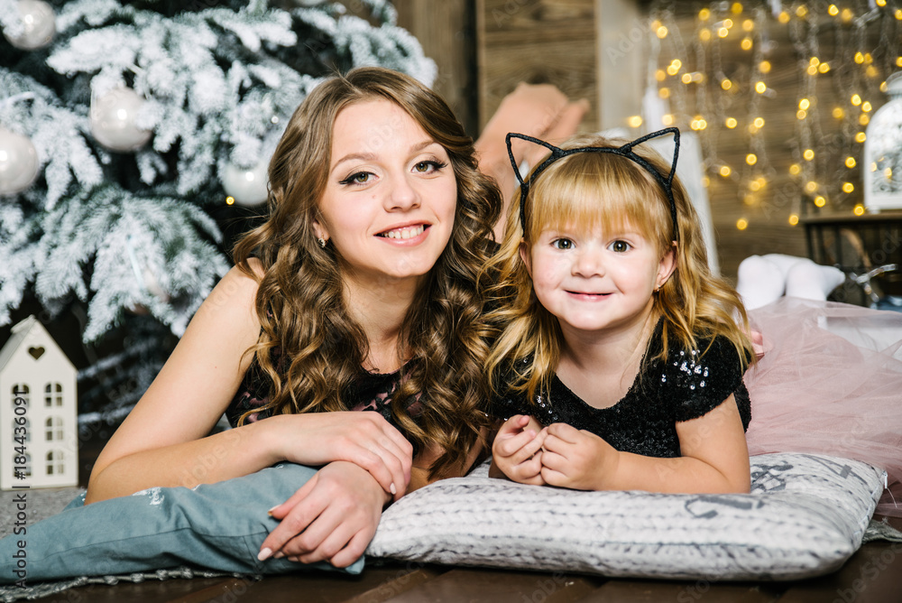 Obraz premium mother with daughter with christmas tree on background