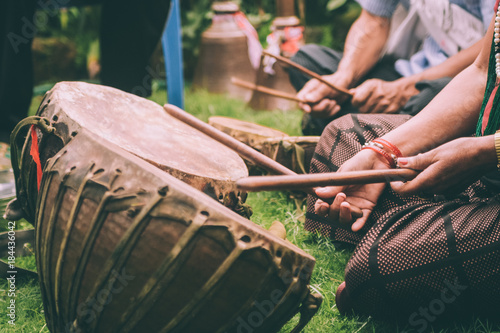 cropped shot of people playing leather drums with sticks in Nepal photo