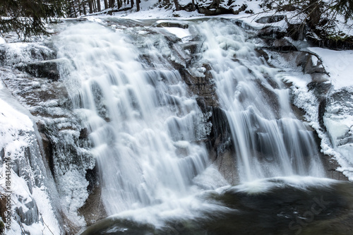 Waterfall in snowy forest. Winter Mumlava Waterfall in Harrachov  Krkonose mountains  Czech Republic