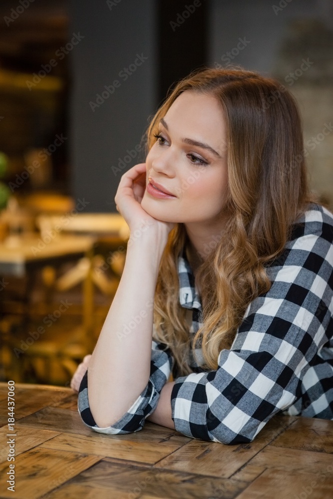 Thoughtful young woman sitting at table Thoughtful young woman sitting at table