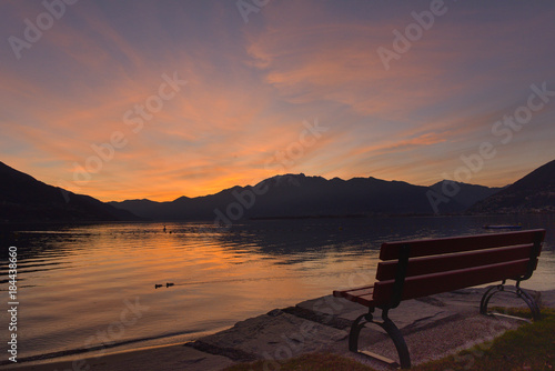 Panchina al molo durante un tramonto serale con cielo colorato di blu, rosa e giallo