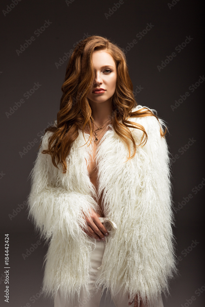 attractive brown-haired woman in fluffy jacket isolated on gray attractive brown-haired woman in fluffy jacket isolated on gray