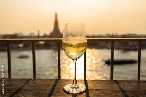 View of Chao Phraya River and Wat Arun background on sunset from bar&restaurant with glasses of wine, Bangkok, Thailand