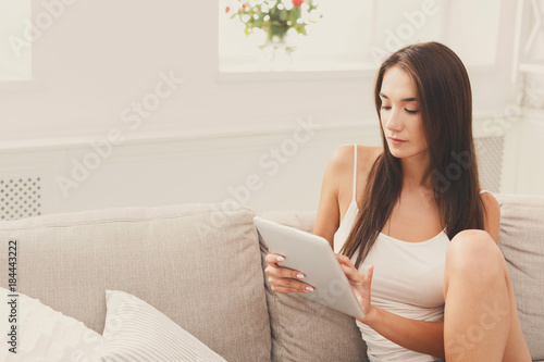 Young thoughtful girl with a tablet at home