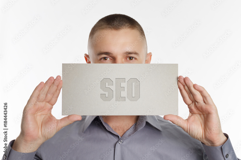 The concept of business, technology, the Internet and the network. Young businessman showing inscription: SEO