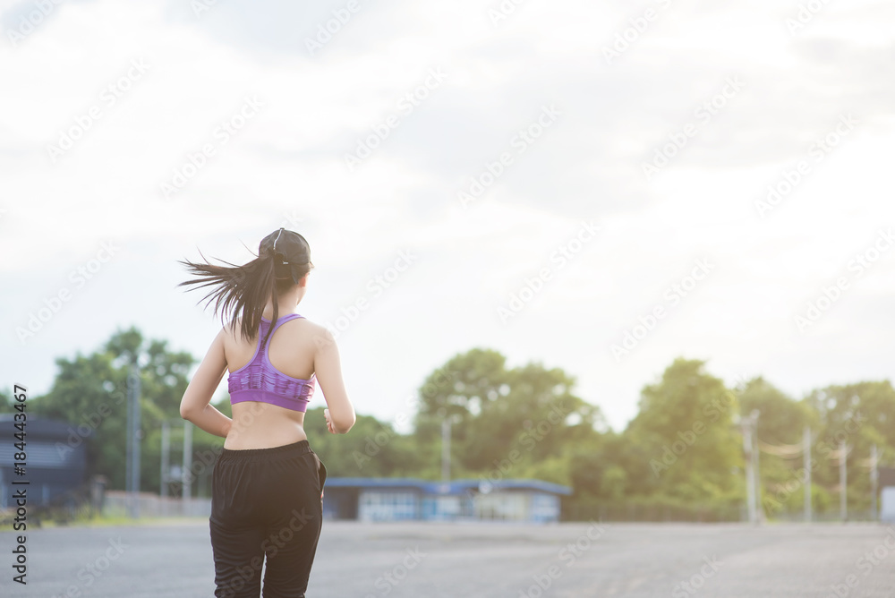 Naklejka premium Young woman runner is jogging on the street be running for exercise. Selective focus