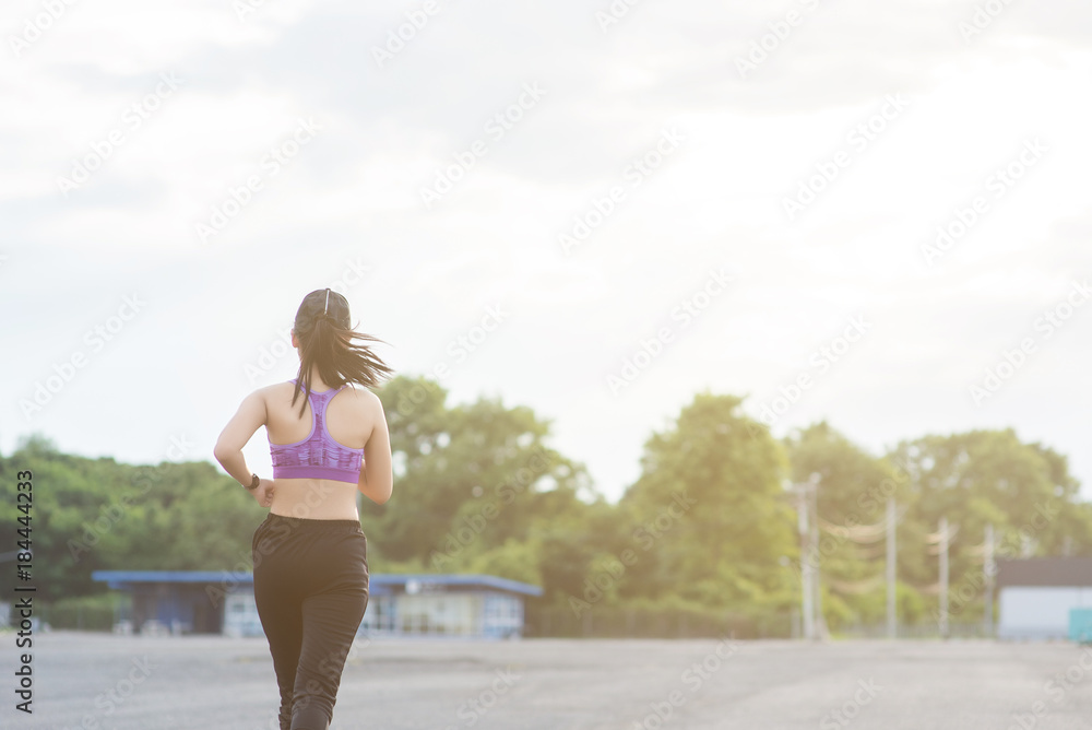 Young woman runner is jogging on the street be running for exercise. Selective focus