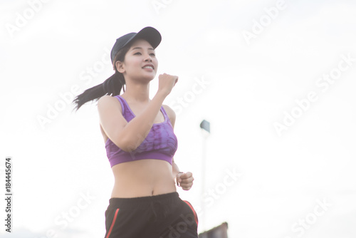 Young woman runner is jogging on the street be running for exercise. Selective focus