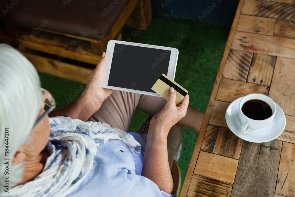 Obraz premium High angle view of woman holding tablet and credit card