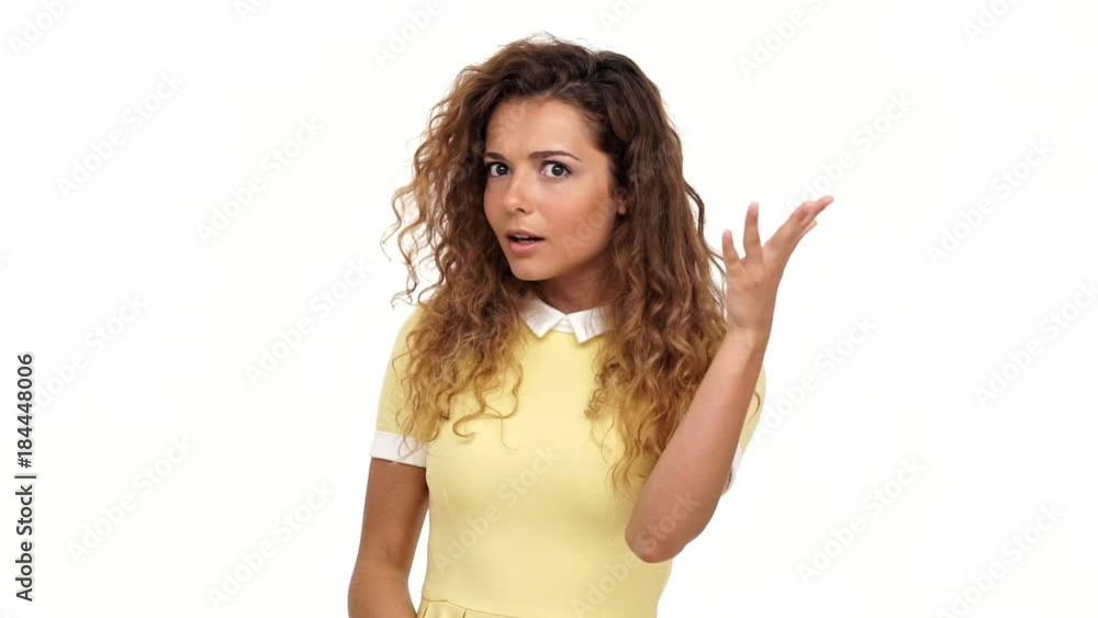 Pretty curly woman in dress hinting at a wedding and indicates the absence of a ring over white background Pretty curly woman in dress hinting at a wedding and indicates the absence of a ring over white background