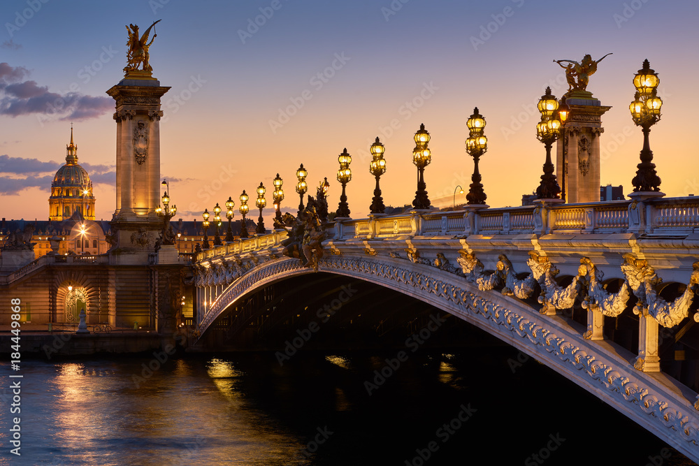 Naklejka premium Pont Alexandre III Most i oświetlone latarnie o zachodzie słońca z widokiem na Invalides. 7. dzielnica, Paryż, Francja