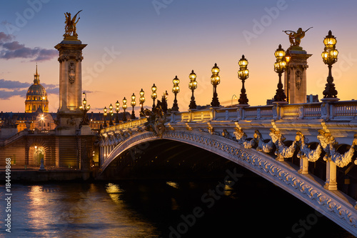Pont Alexandre III Bridge and illuminated lamp posts at sunset with view of the Invalides. 7th Arrondissement, Paris, France