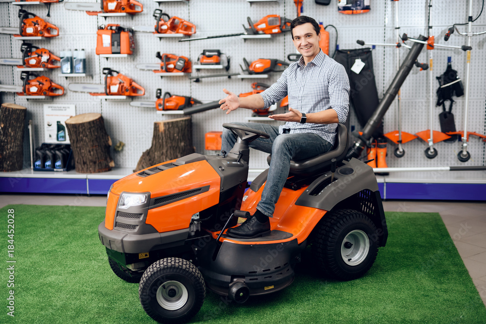 Fototapeta premium A man is sitting on a lawn mower.