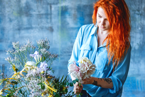 Charming cheerful female shop assistant making transparent carcass bouquet with Eucalyptus poplaraceous populus and Chrysanthemum single-headed Anastasia white photo