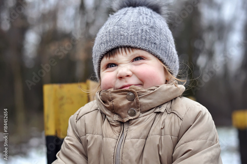 Happy child playing outdoors. Kid having fun in winter park