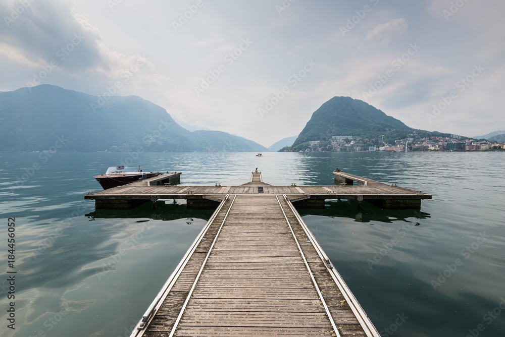 Boat pier on the Lake Lugano, Switzerland. European vacation, travel and nautical concept.