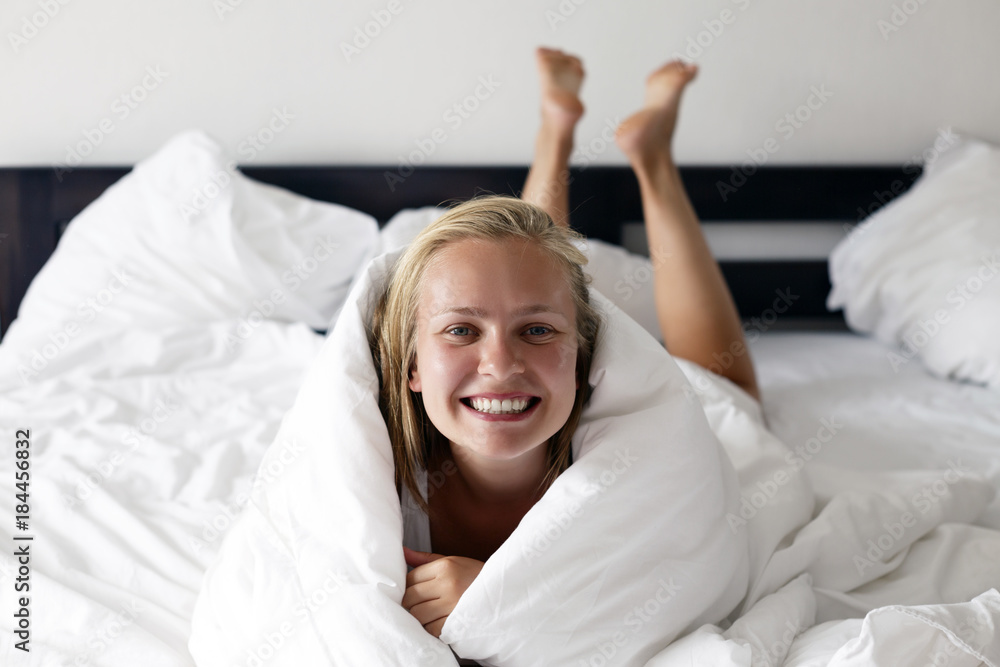 Morning time. Young beautiful and happy woman lies in bed. Morning time. Young beautiful and happy woman lies in bed.