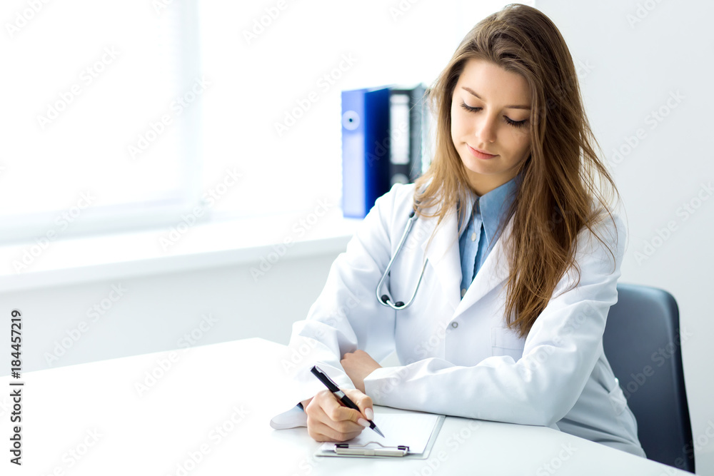 Doctor makes notes in a notebook sitting in the office Doctor makes notes in a notebook sitting in the office