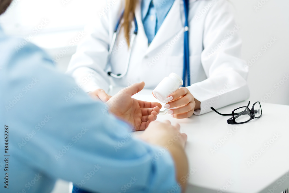 Doctor writes out the pills to the patient Doctor writes out the pills to the patient