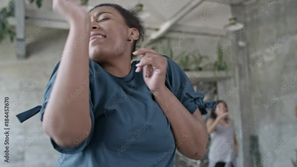Medium shot of ecstatic African woman dancing zumba in group class Medium shot of ecstatic African woman dancing zumba in group class