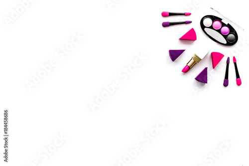 Makeup set pattern. Eyeshadows, lipstick, applicators on white background top view copyspace