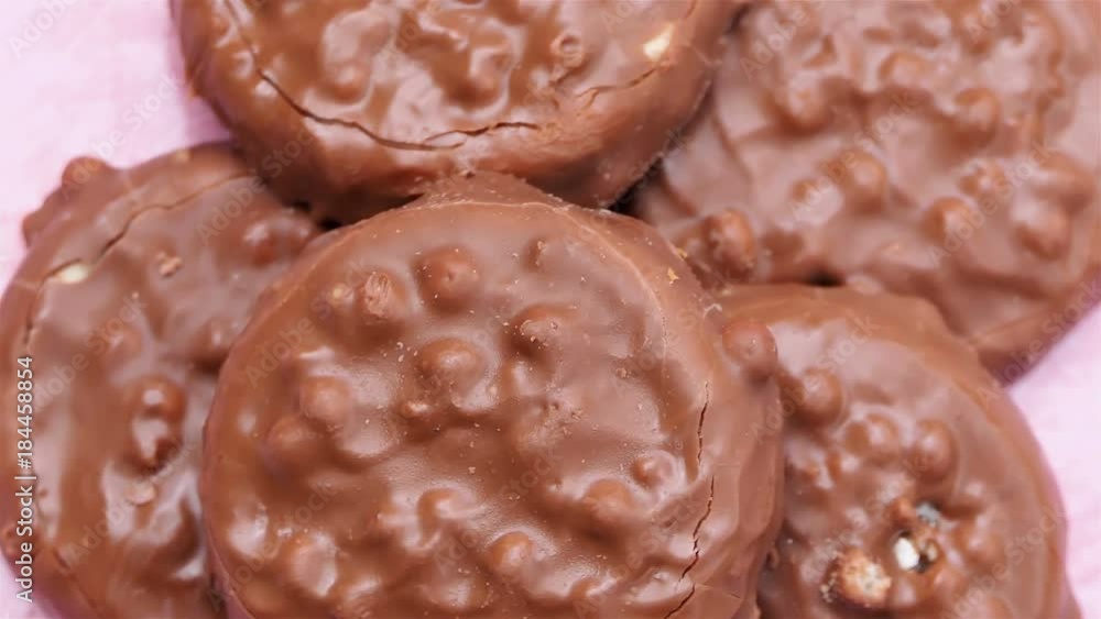 Chocolate Chip Cookies rotation 4k. close up heap of Chocolate Chip Cookies on pink artisan plate in sunlight over green background. homemade dessert. food background. appetizing dessert. Chocolate Chip Cookies rotation 4k. close up heap of Chocolate Chip Cookies on pink artisan plate in sunlight over green background. homemade dessert. food background. appetizing dessert.
