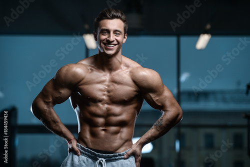 sexy strong bodybuilder athletic men pumping up muscles
