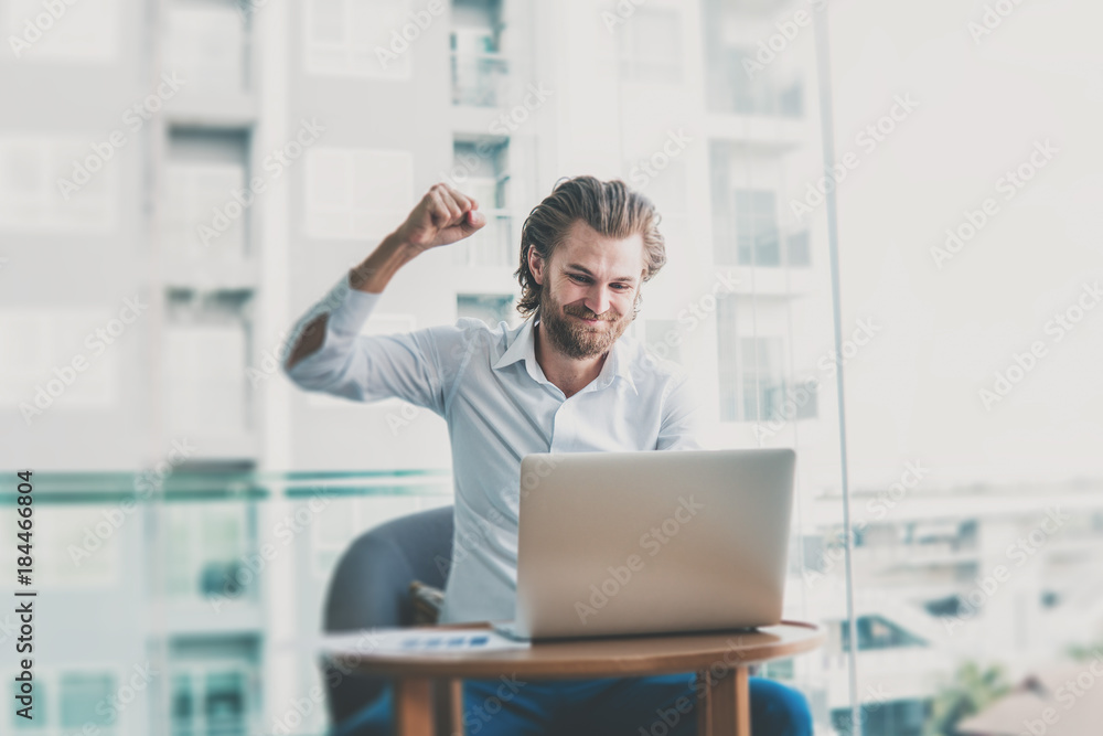Casual dressed white business man celebrate with laptop. Education or technology or startup business concept, modern office or living room with copy space Casual dressed white business man celebrate with laptop. Education or technology or startup business concept, modern office or living room with copy space