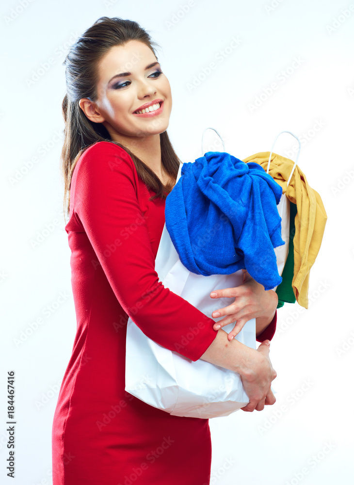 Beautiful young woman in red dress holding shopping bag with clo Beautiful young woman in red dress holding shopping bag with clo
