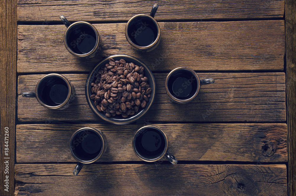 empty cups and a saucer with grains on a board surface empty cups and a saucer with grains on a board surface